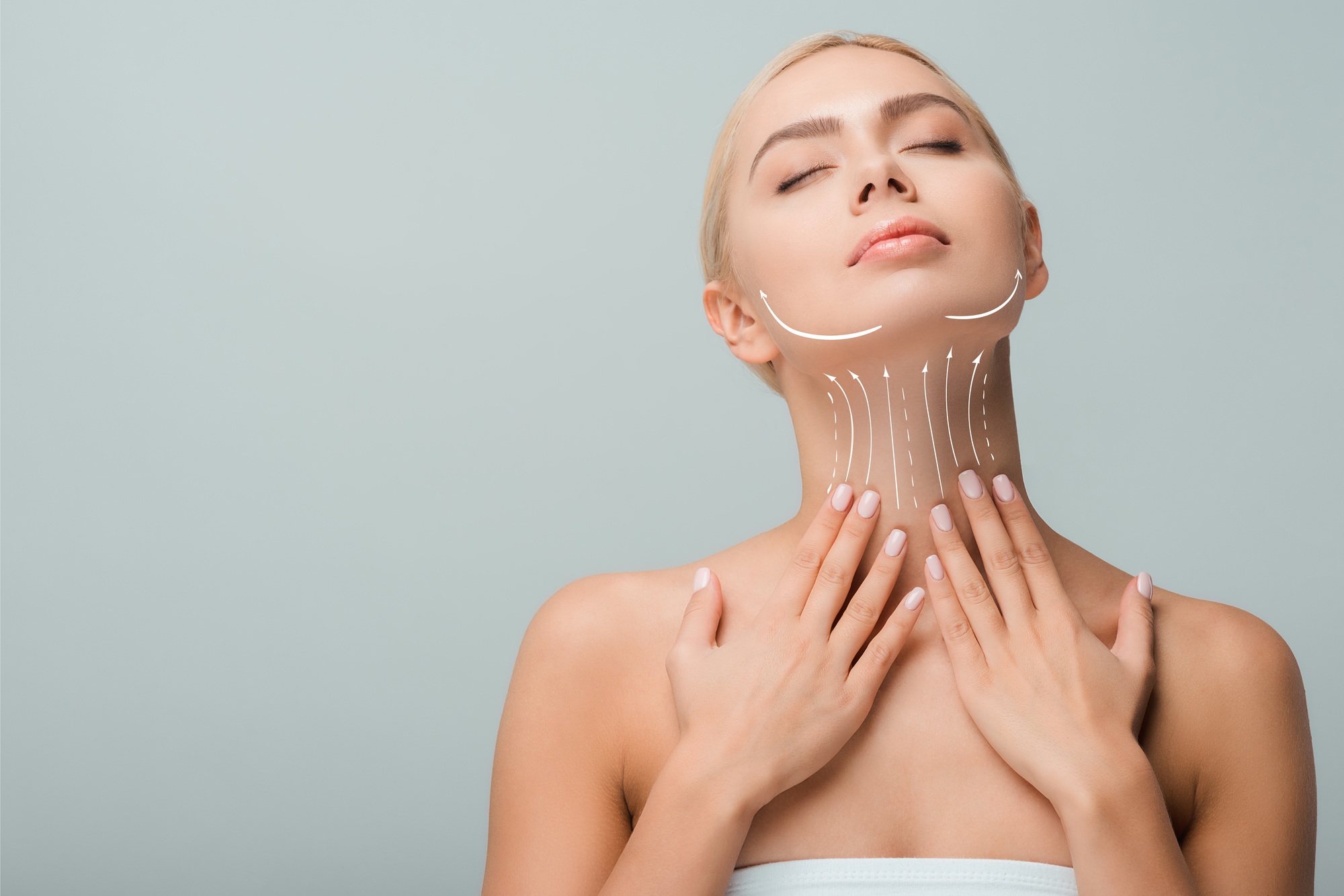 beautiful woman touching neck with lifting marks isolated on grey